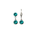 The Simple Drop Blue Zircon Earrings by Anne Koplik Designs, Inc. feature two round blue zircon stones per earring—a stud at the top and a dangling stone below—joined by a small loop for a classic look.