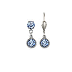 The Simple Drop Light Sapphire Earrings by Anne Koplik Designs, Inc. are silver-toned with a timeless look—one earring has two round light blue stones, the other features a single gemstone and a decorative silver accent at the top.