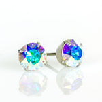 The Simple Post Crystal Earrings by Anne Koplik Designs, Inc. feature radiant round crystals in silver prongs, shimmering with blue, green, and purple hues—ideal for bridesmaid jewelry.