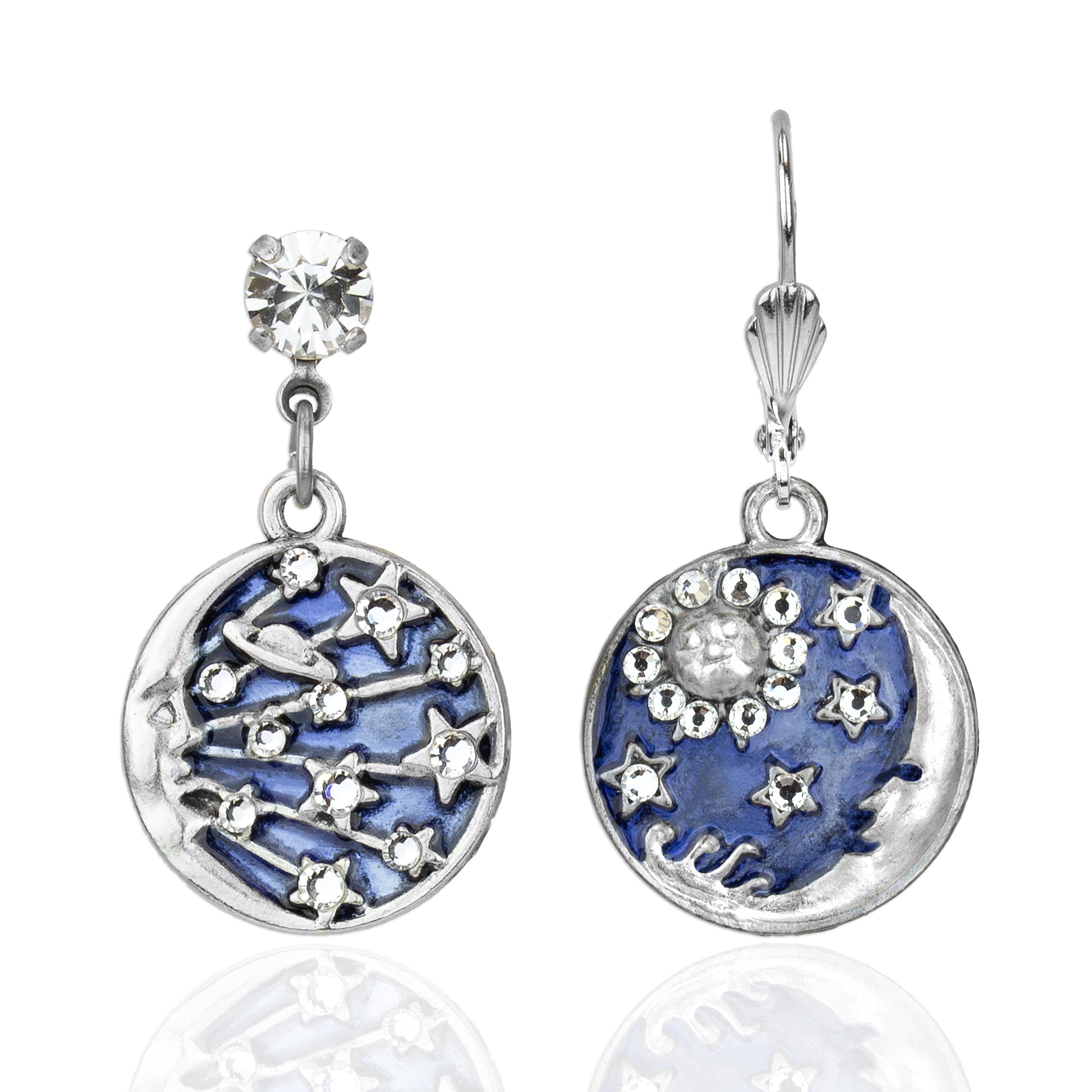 The Enamel & Stone 1 Moon/1 Star Earrings by Anne Koplik Designs, Inc. feature silver drop earrings with galaxy-inspired blue enamel pendants—one with stars and planets, the other with a sun and moon—each topped with a sparkling stud.