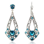 The Anne Koplik Designs, Inc. Open Leaf Pendulum Teal Earrings feature an ornate antiqued silver filigree design and symmetrically arranged round teal stones. Lead- and nickel-free for comfortable, stylish wear.