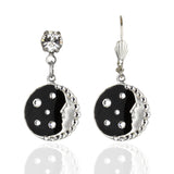 The Man in the Moon Black Background/Enamel & Stone Earrings by Anne Koplik Designs, Inc. feature a silver-plated moon face with black enamel, clear crystal accents, and a round gemstone detail.