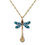 The Enamel & Stone Teal Dragonfly/Amber Drop Necklace by Anne Koplik Designs, Inc. features a gold chain, blue-winged dragonfly pendant with green, white, and brown gems, and an amber drop—perfect for artisanal teal jewelry lovers.