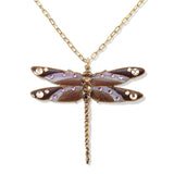 The Enamel & Stone Mocha/Lavender Dragonfly Necklace by Anne Koplik Designs, Inc. features a gold chain with a detailed dragonfly pendant in purple, brown, and gold enamel with gemstone accents on an adjustable brass chain. Lead free.