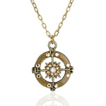 The Whimsy Fancy Stone Compass Necklace by Anne Koplik Designs, Inc. features a gold chain and vintage-style round pendant with crystal accents, a central opalescent stone, directional points, and decorative details—ideal for adventure lovers.