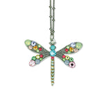The Multi Stone Medium Dragonfly Necklace by Anne Koplik Designs, Inc. features a silver-plated chain with colorful gemstones in blue, pink, green, and yellow for a vibrant statement.