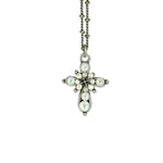 The Small Stone Fancy Cross White Opal Necklace by Anne Koplik Designs, Inc. features a vintage-inspired cross pendant with round white opal stones and sparkling crystals in a floral pattern on a silver chain, displayed against a white background.