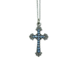 The Anne Koplik Designs, Inc. Mini Blue Crystal Pave Cross Necklace features a silver-plated cross pendant with blue crystals and decorative edges, suspended from a silver chain on a white background.
