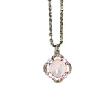 The Simple Clover/Faceted Stone Rose Opal Necklace by Anne Koplik Designs, Inc. features a silver chain with a cushion-cut pendant, showcasing a pale pink faceted stone and pink/clear crystals in an ornate vintage-inspired setting.